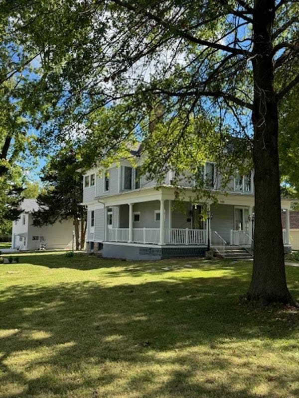 view of front of home with covered porch and a front lawn