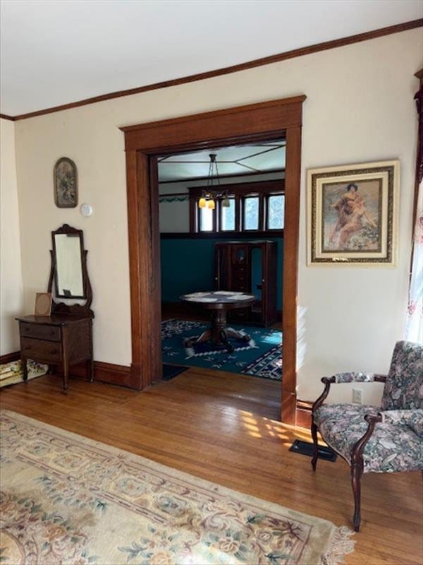 corridor with hardwood / wood-style floors and ornamental molding