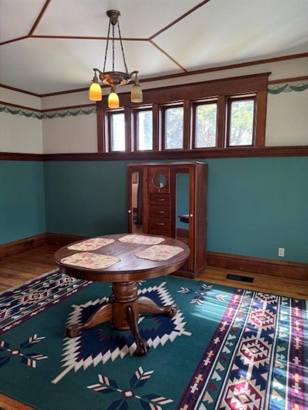 unfurnished dining area with hardwood / wood-style floors and a chandelier