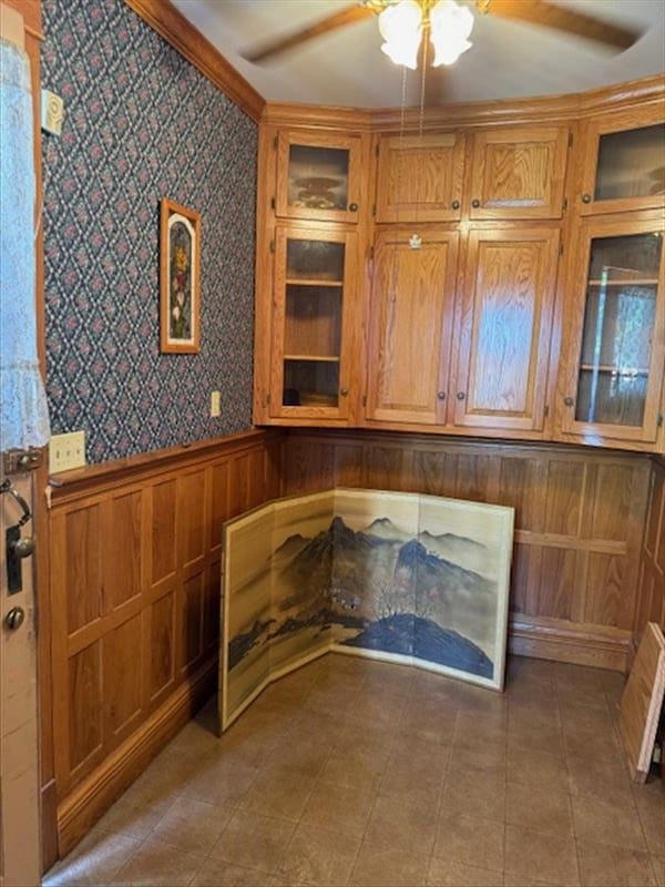 interior space with ceiling fan and wood walls