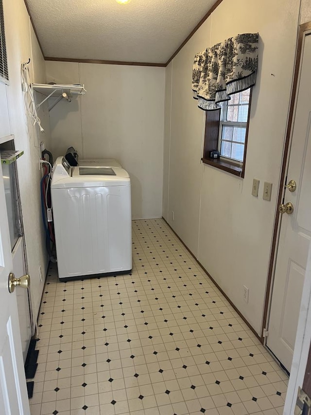 washroom featuring a textured ceiling, light floors, laundry area, and crown molding