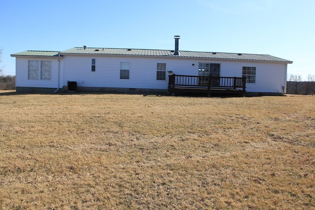 back of property with cooling unit, crawl space, a deck, a lawn, and metal roof