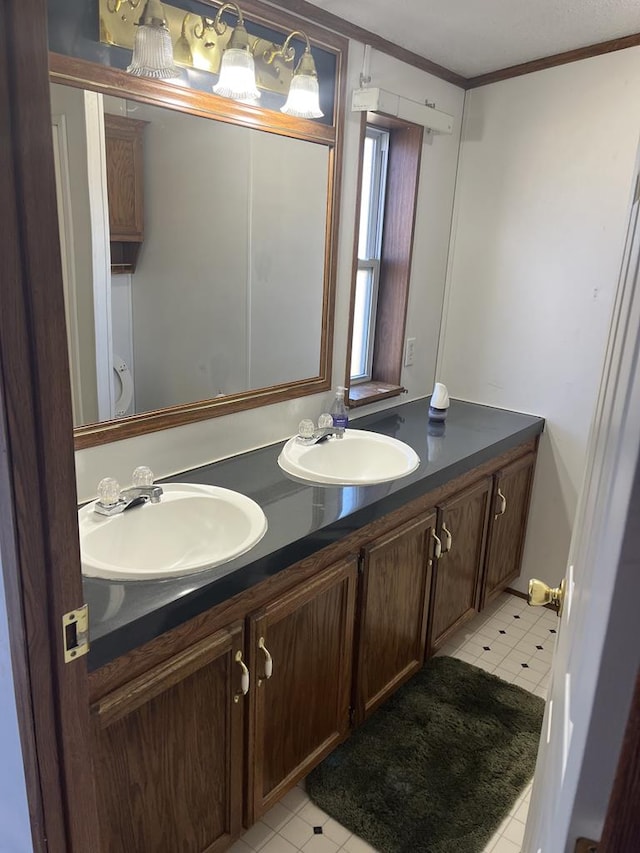 full bath with double vanity, ornamental molding, tile patterned floors, and a sink