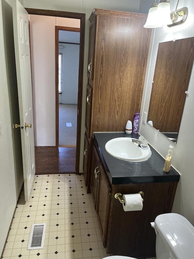 bathroom featuring vanity, tile patterned floors, toilet, and visible vents