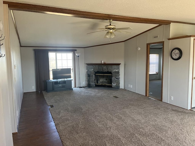 unfurnished living room with crown molding, lofted ceiling with beams, a fireplace, a textured ceiling, and a ceiling fan