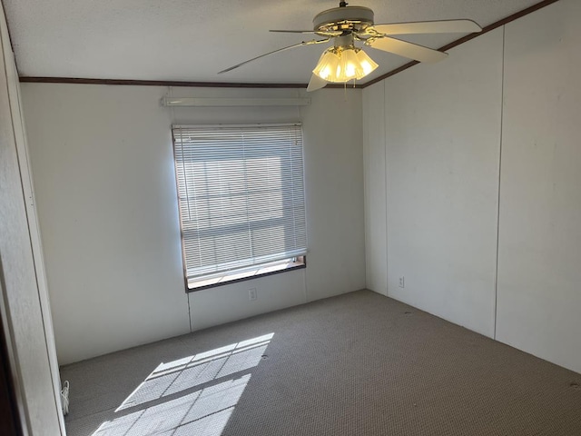 carpeted empty room featuring a ceiling fan and ornamental molding