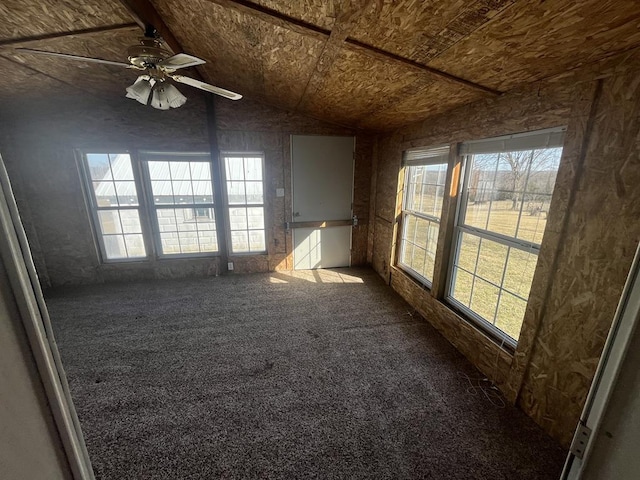 unfurnished room with dark colored carpet, ceiling fan, and vaulted ceiling