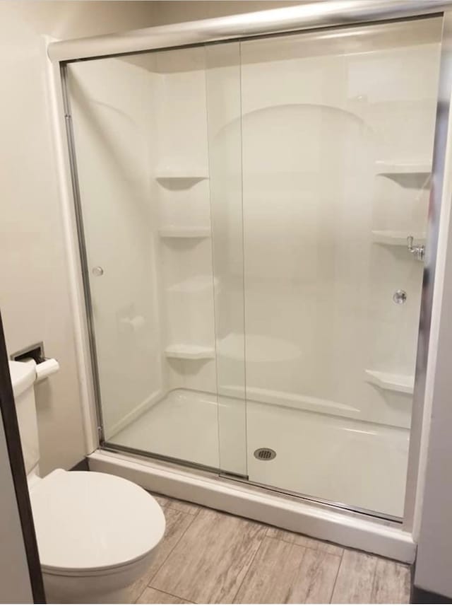 101 S Main St, Usa, Marceline, MO 64658 - full bathroom with a stall shower, toilet, and wood finished floors