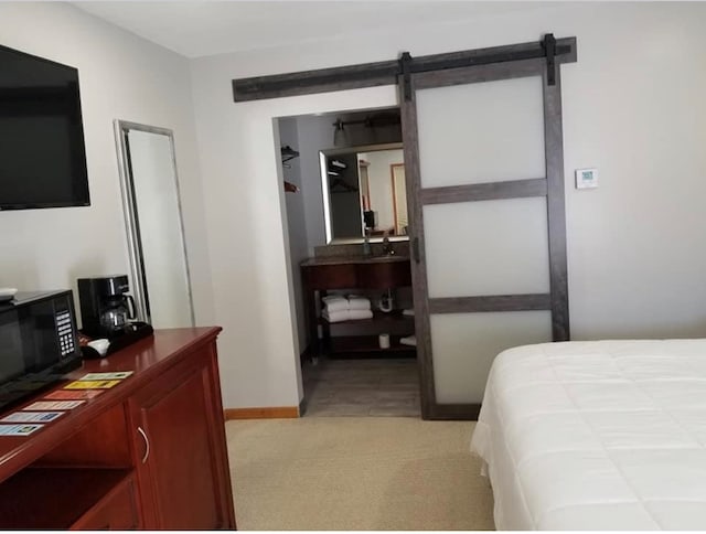 101 S Main St, Usa, Marceline, MO 64658 - bedroom featuring light carpet, baseboards, and a barn door