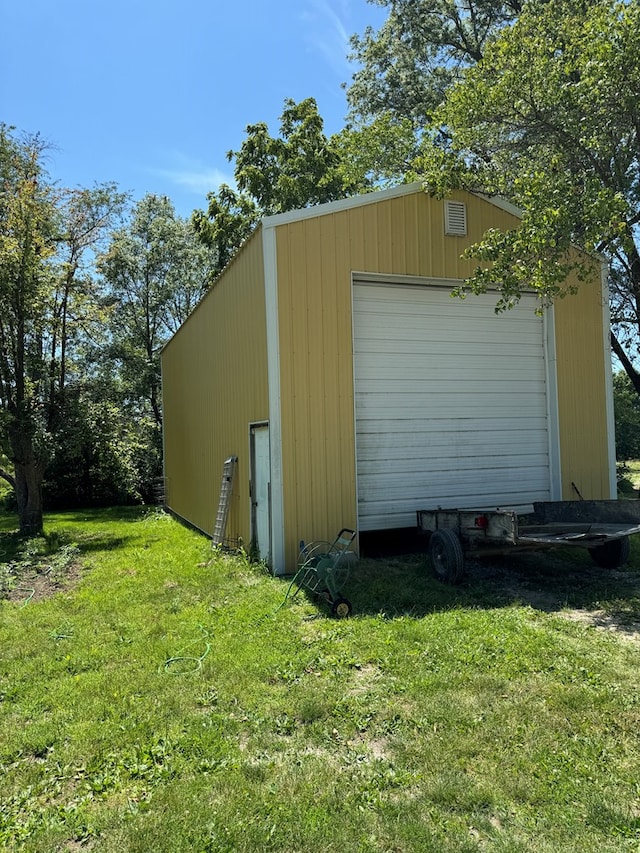 view of outdoor structure featuring a garage and a lawn