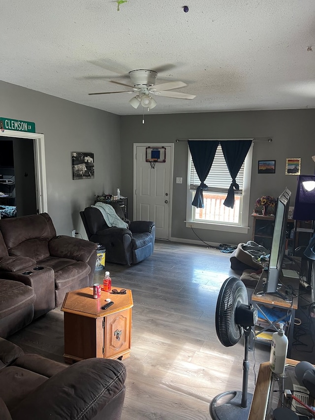 living room featuring ceiling fan, hardwood / wood-style floors, and a textured ceiling