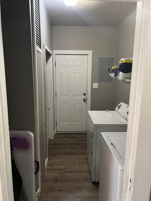 washroom with electric panel, washer and clothes dryer, and dark wood-type flooring