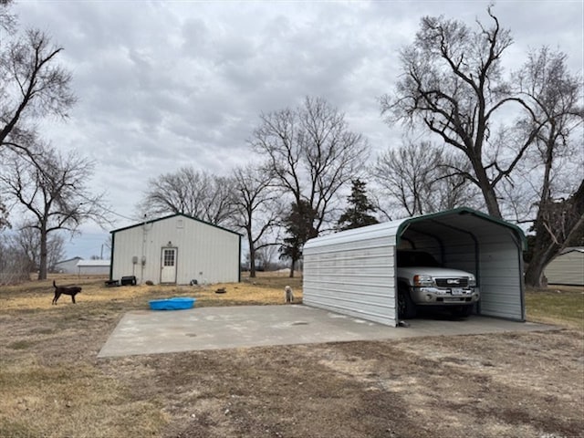 view of parking / parking lot with dirt driveway and a carport