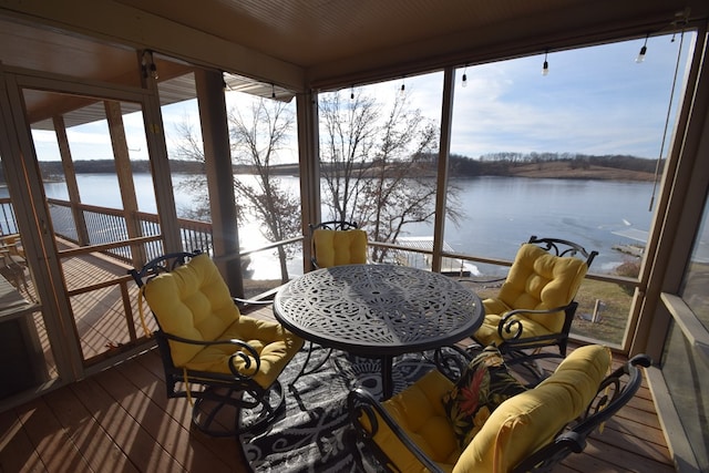 sunroom / solarium with a water view and plenty of natural light