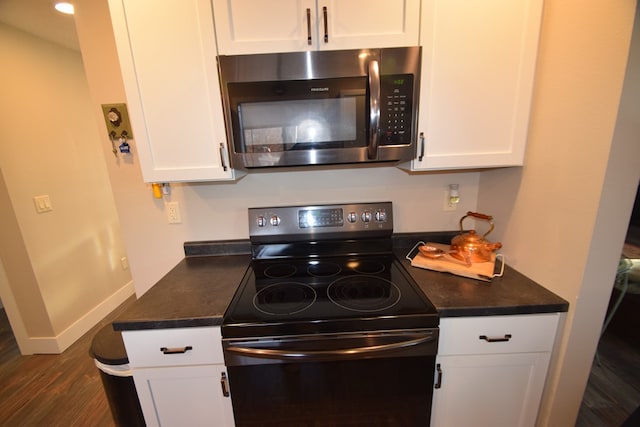 kitchen featuring range with electric stovetop, dark wood-type flooring, and white cabinetry