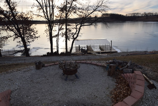 exterior space featuring a water view and a fire pit