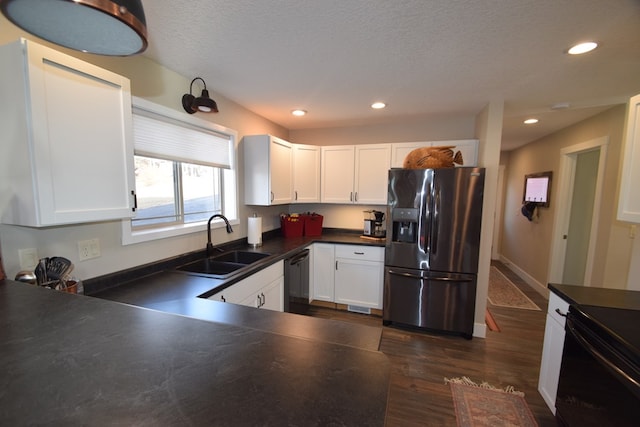 kitchen with white cabinetry, black dishwasher, dark hardwood / wood-style flooring, sink, and stainless steel fridge