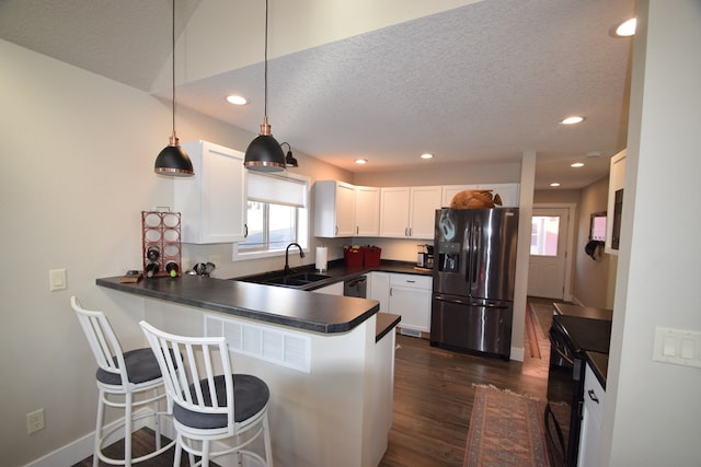 kitchen with black appliances, white cabinets, kitchen peninsula, and hanging light fixtures