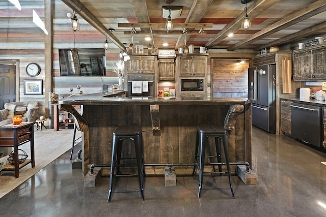 kitchen featuring black appliances, a breakfast bar, wood walls, and a large island