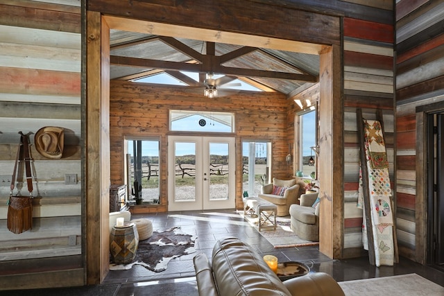 unfurnished living room with plenty of natural light, ceiling fan, high vaulted ceiling, and french doors