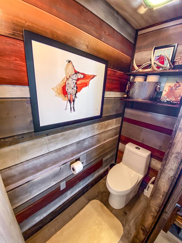 bathroom featuring wood walls and toilet