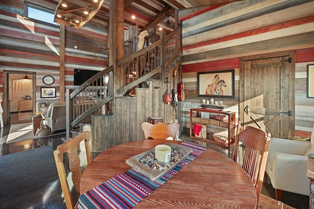 dining area with a high ceiling and wooden walls