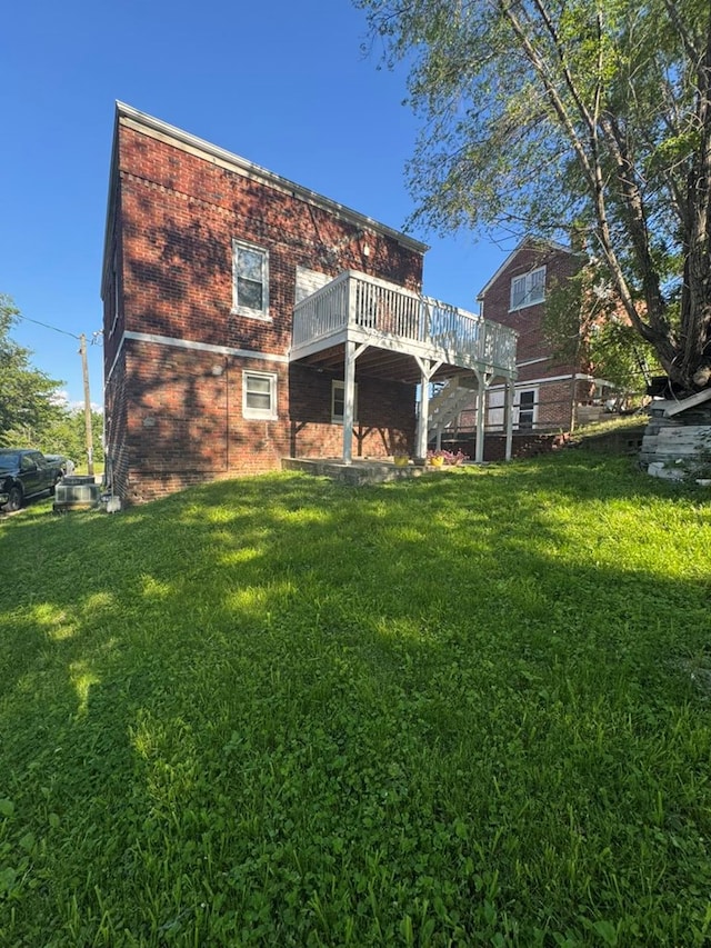113 Elm St, Milan, MO 63556 - back of property featuring brick siding, a deck, and a yard