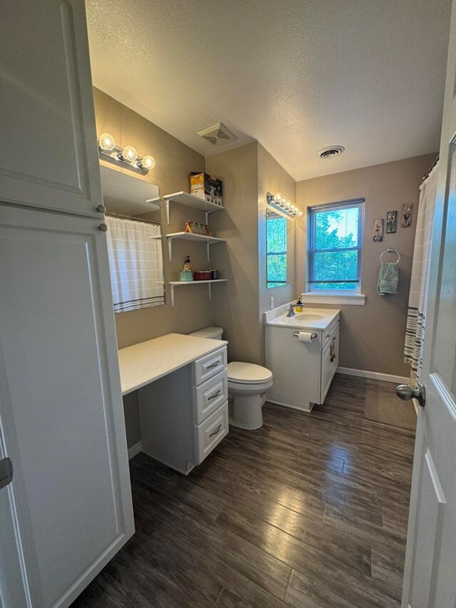 113 Elm St, Milan, MO 63556 - full bath featuring vanity, wood finished floors, a textured ceiling, toilet, and baseboards