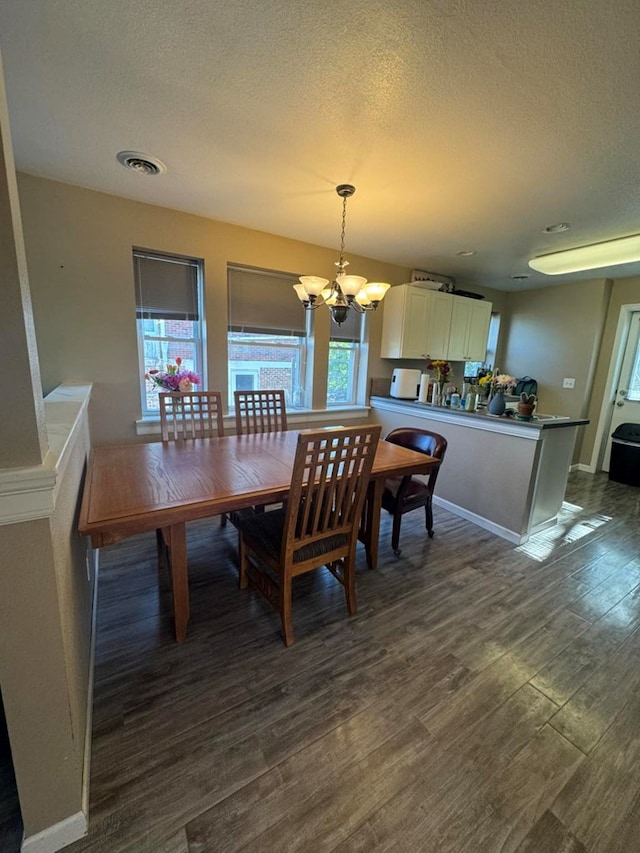 113 Elm St, Milan, MO 63556 - dining space with a chandelier, dark wood-type flooring, a textured ceiling, and baseboards