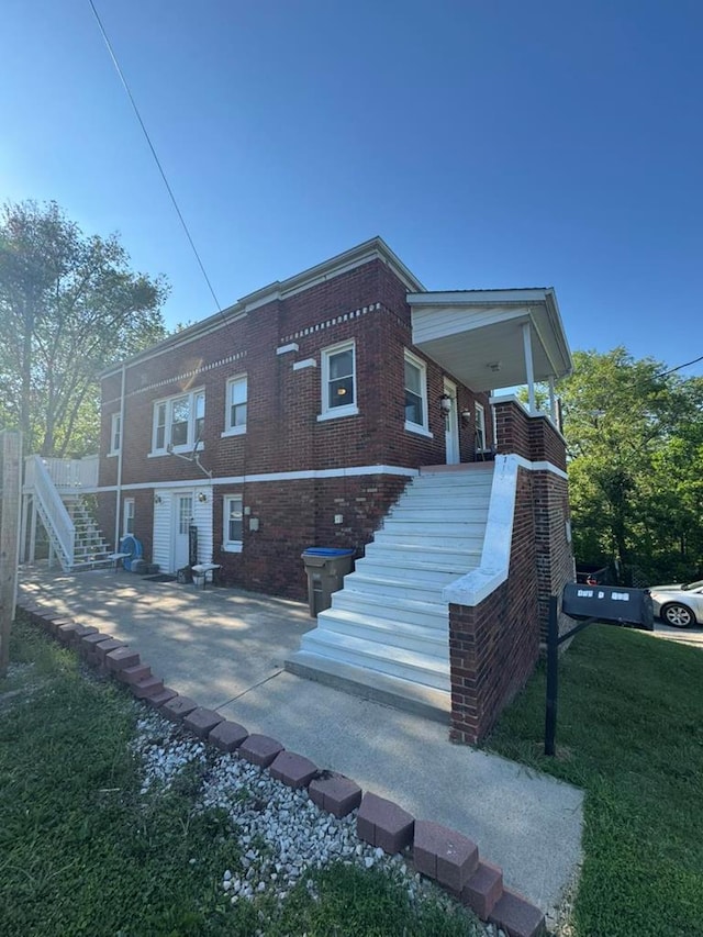 113 Elm St, Milan, MO 63556 - back of property with stairs, brick siding, and a lawn