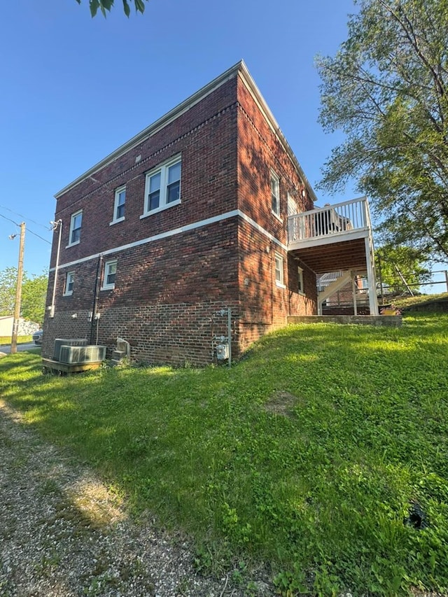 113 Elm St, Milan, MO 63556 - view of side of home featuring brick siding, a wooden deck, and a yard