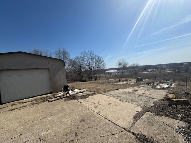 view of patio / terrace featuring an outbuilding, driveway, and a garage