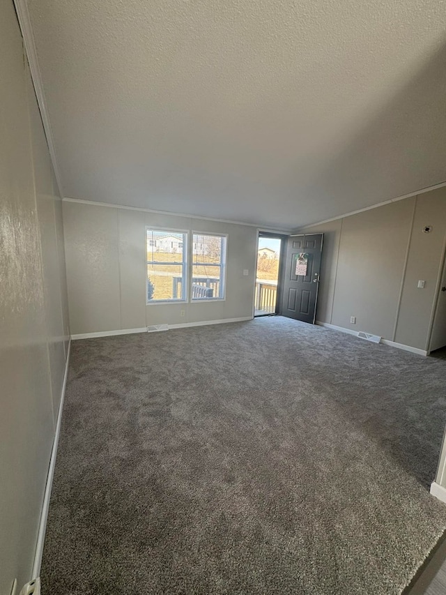 unfurnished living room with visible vents, baseboards, a textured ceiling, and carpet