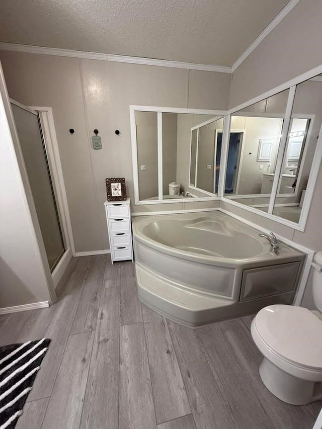 bathroom with toilet, ornamental molding, a stall shower, wood finished floors, and a textured ceiling