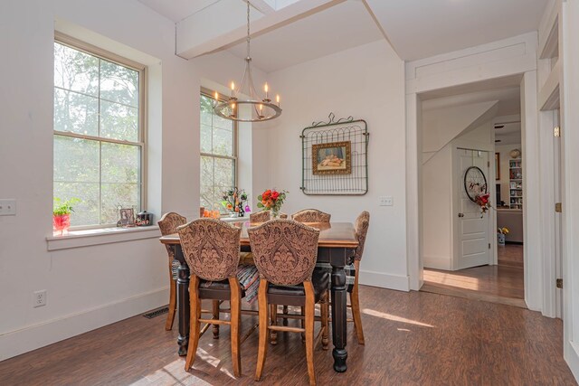 dining room with a wealth of natural light, visible vents, an inviting chandelier, and wood finished floors