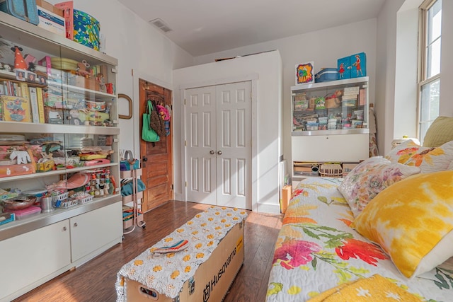 bedroom featuring a closet, wood finished floors, and visible vents