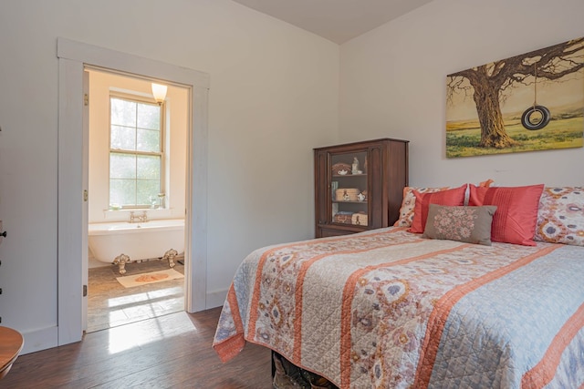 bedroom featuring ensuite bath and dark wood finished floors