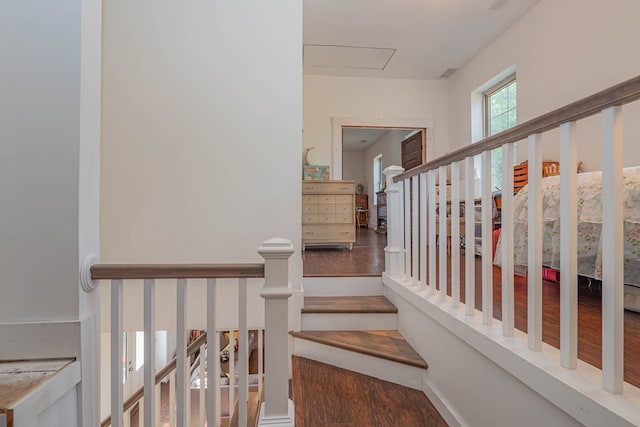 staircase with attic access and wood finished floors