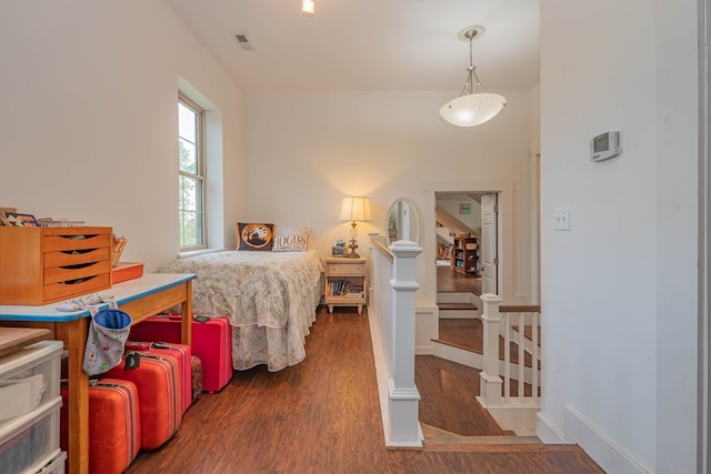 bedroom featuring visible vents, baseboards, and wood finished floors