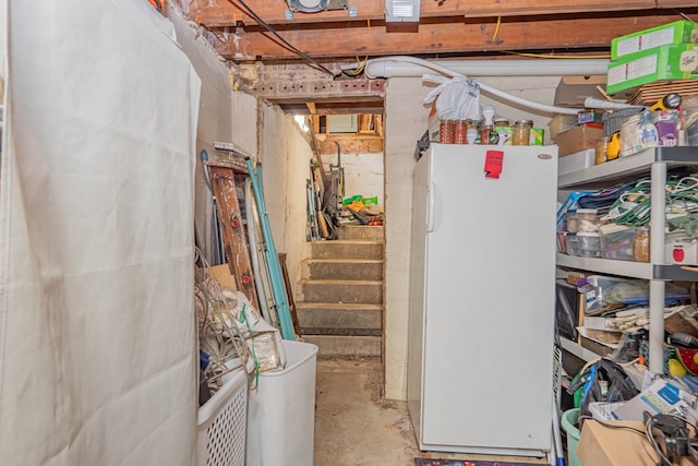 unfinished below grade area with stairs and freestanding refrigerator