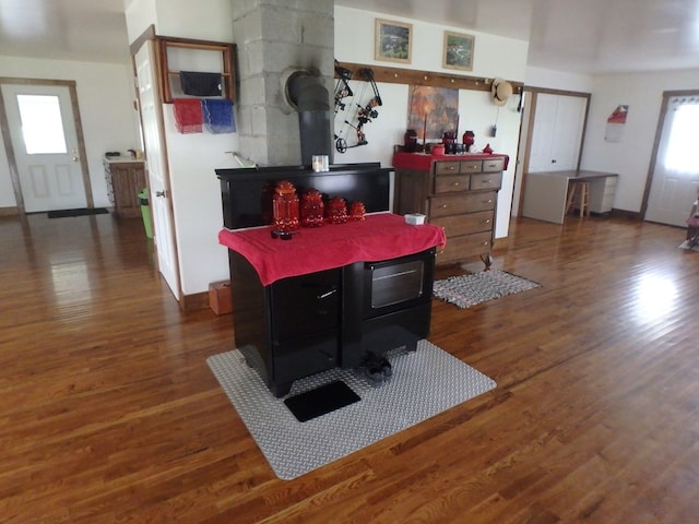 dining room with dark hardwood / wood-style floors and a wood stove