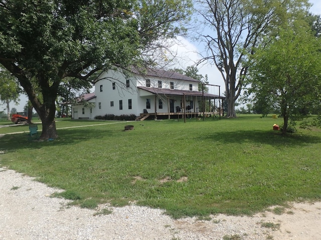 view of front facade with a wooden deck and a front lawn