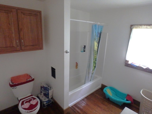 bathroom with shower / bath combo with shower curtain, wood-type flooring, and toilet