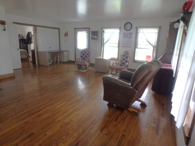 living room with dark hardwood / wood-style floors and a healthy amount of sunlight