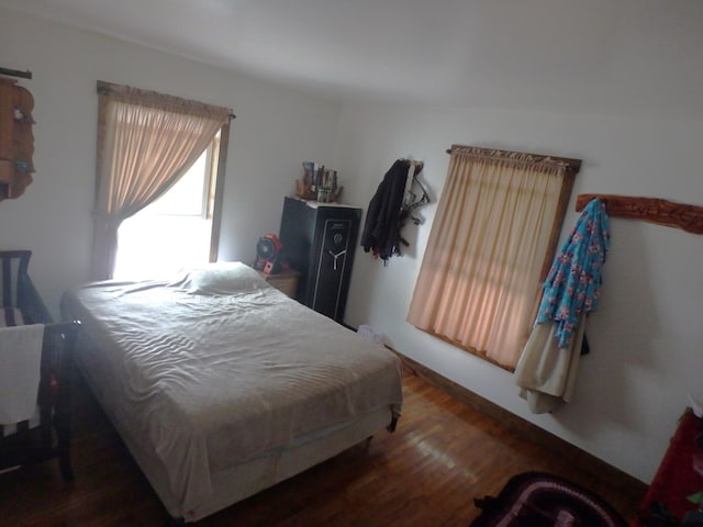 bedroom with dark hardwood / wood-style flooring