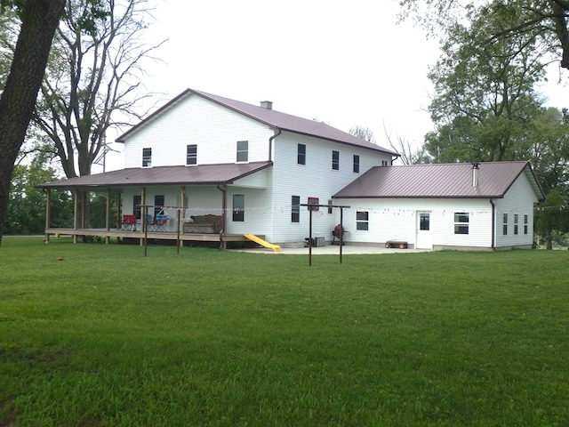 rear view of property with a yard, a patio, and a wooden deck