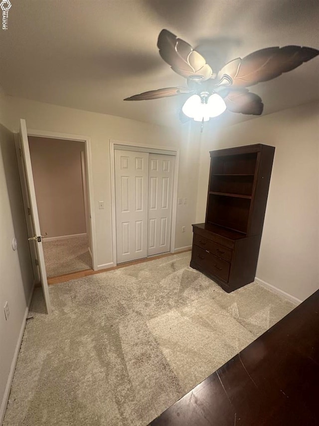 unfurnished bedroom featuring ceiling fan, a closet, and carpet