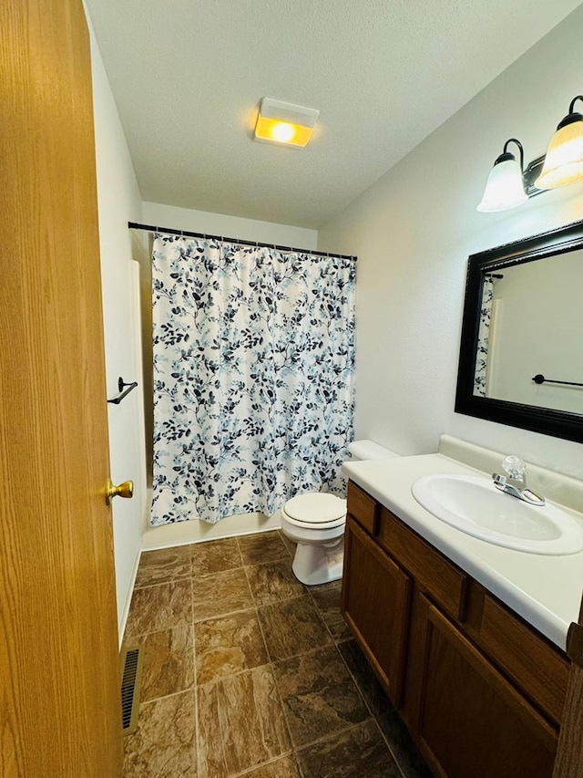 full bathroom featuring a textured ceiling, vanity, toilet, and shower / bath combo with shower curtain