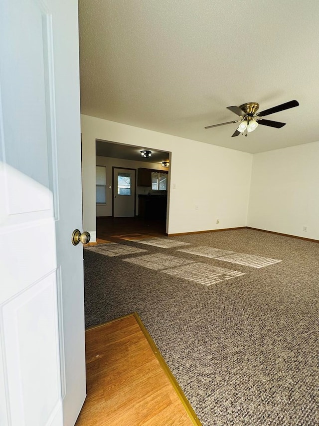 carpeted spare room featuring ceiling fan and a textured ceiling