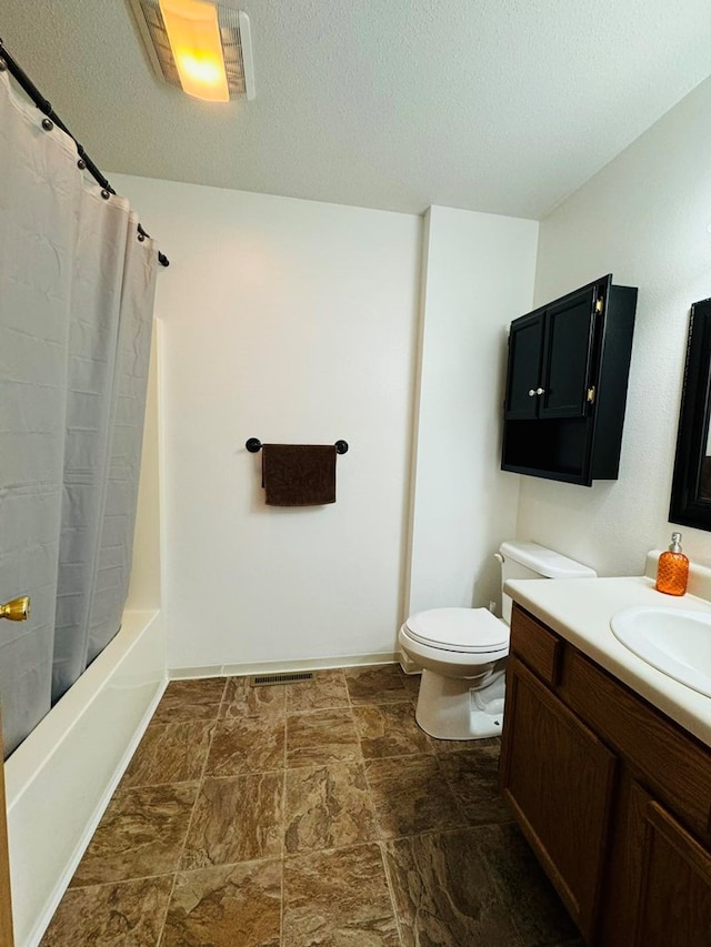 full bathroom featuring a textured ceiling, vanity, toilet, and shower / tub combo with curtain